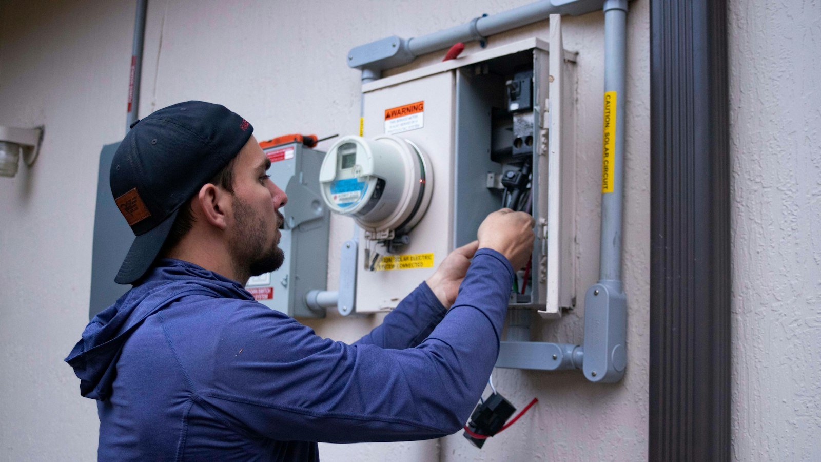 Electrician checking a commercial electrical meter and fuse panel
